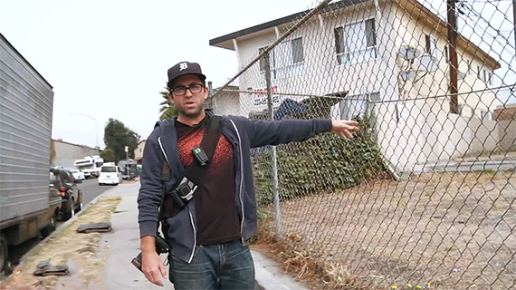 Nee points out the spot where he was incarerated. The body camera he used to capture his arrest can be seen attached to the strap across his chest.