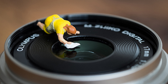 miniature person cleaning a lens