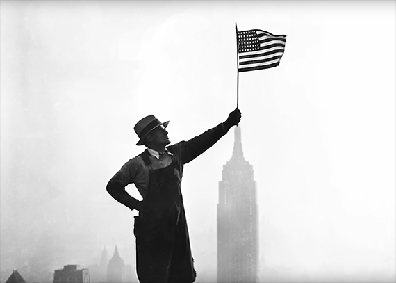 construction worker poses with flag 