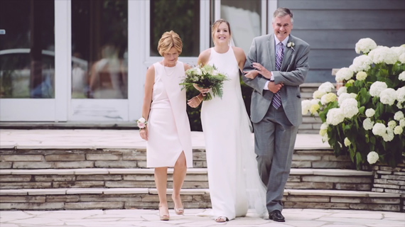 bride walking down the aisle with parents