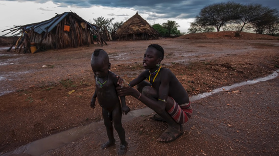 child being bathed in rain water