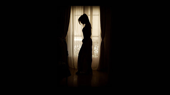 silhouette of woman standing in front of window